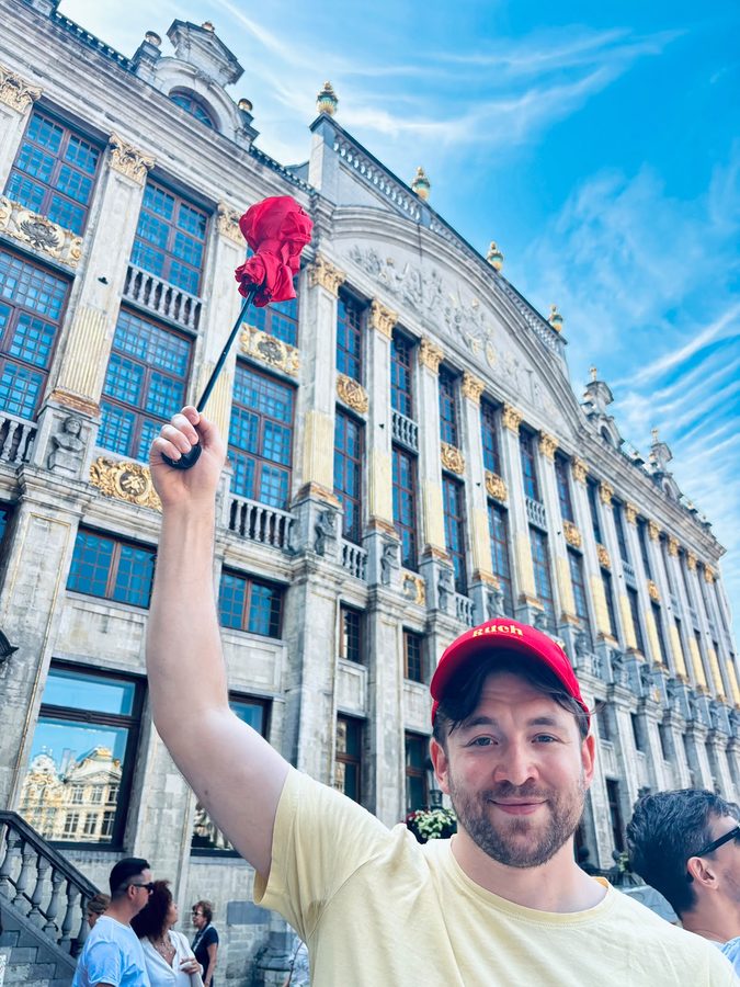 Simon mit roter Ruch-Cap und Tour-Fähnchen an der Grand-Place in Brüssel